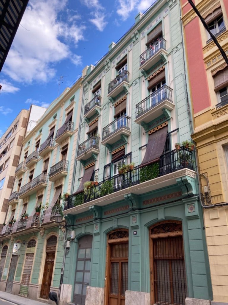 Façade d’un immeuble ancien à Valencia avec des locaux commerciaux au rez-de-chaussée pouvant être transformés en logements.