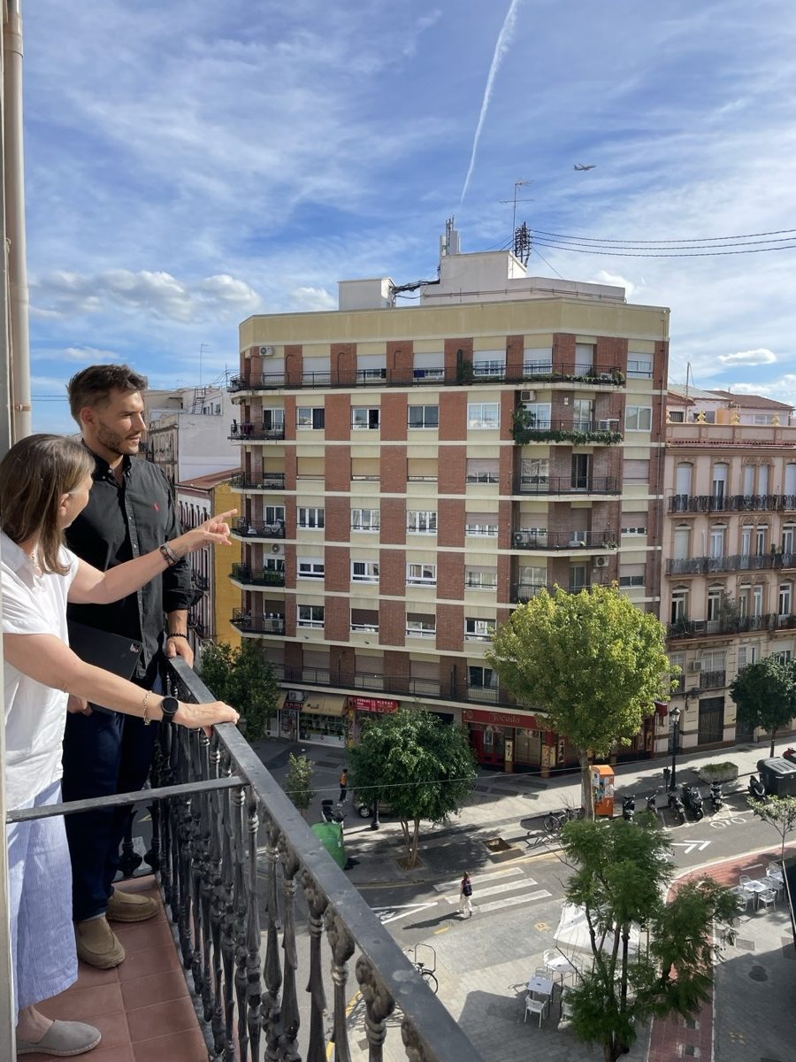 Un conseiller BuenApart montre le quartier à une cliente depuis le balcon d'un appartement de Valence.